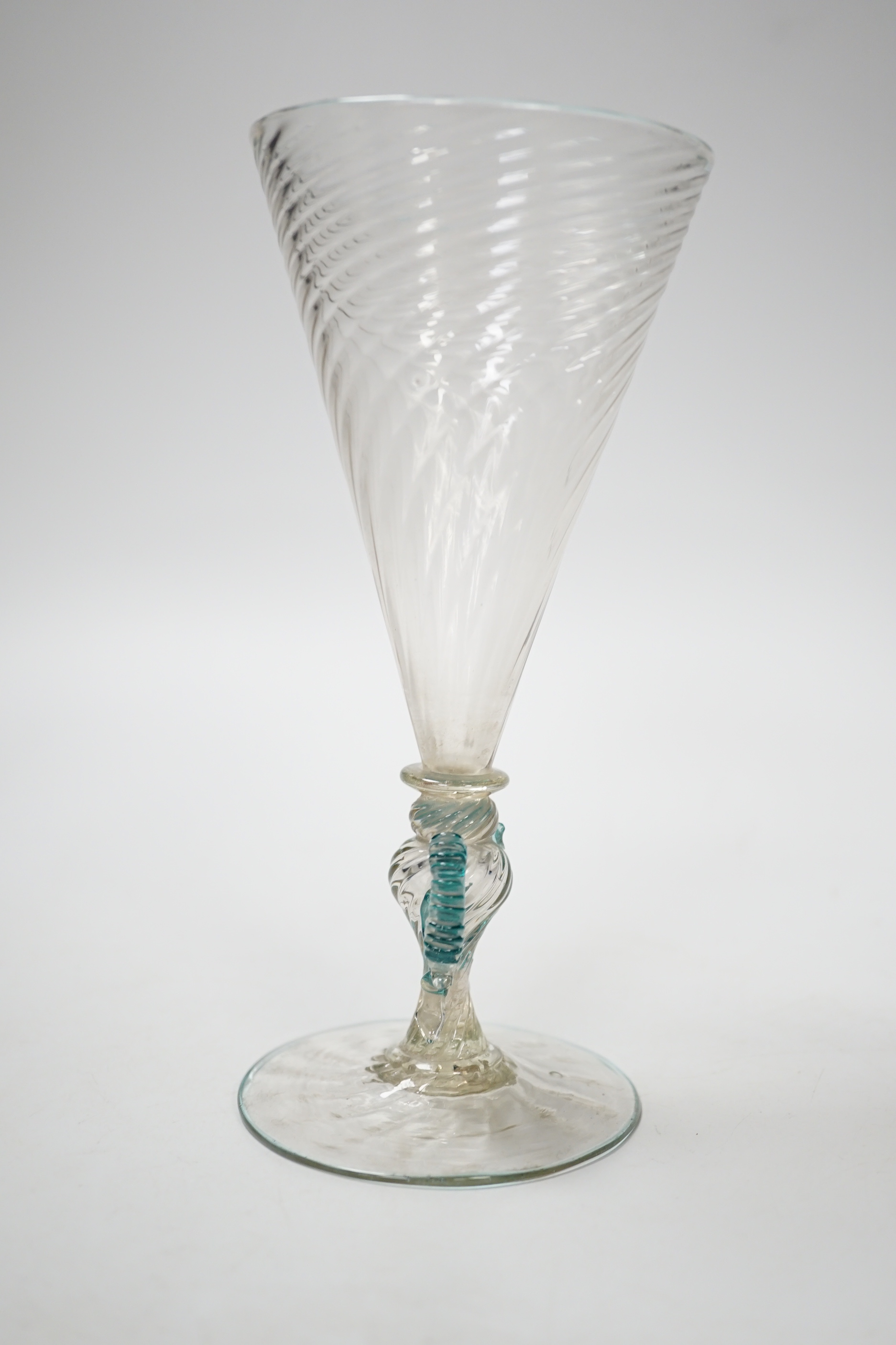 A Facon de Venise wine glass, c.1800, the round funnel bowl is spiral moulded over a blade knop, round knop and inverted baluster with applied turquoise ears, on spiral moulded foot with rough pontil, 16.9cm high